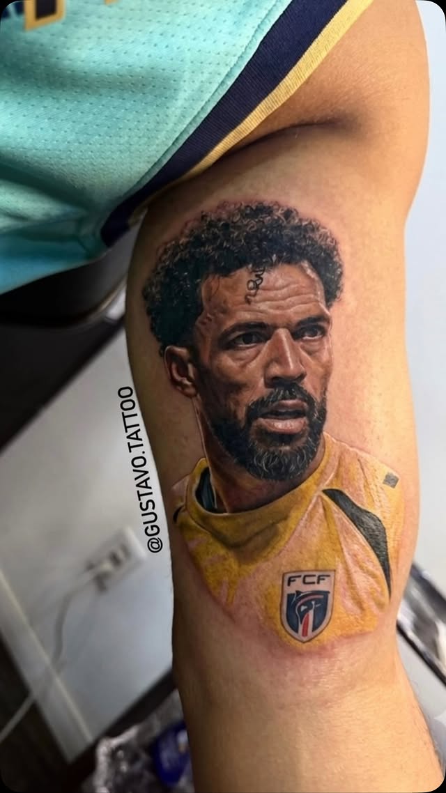 Retrato de jogador de futebol tatuado na perna, em cor